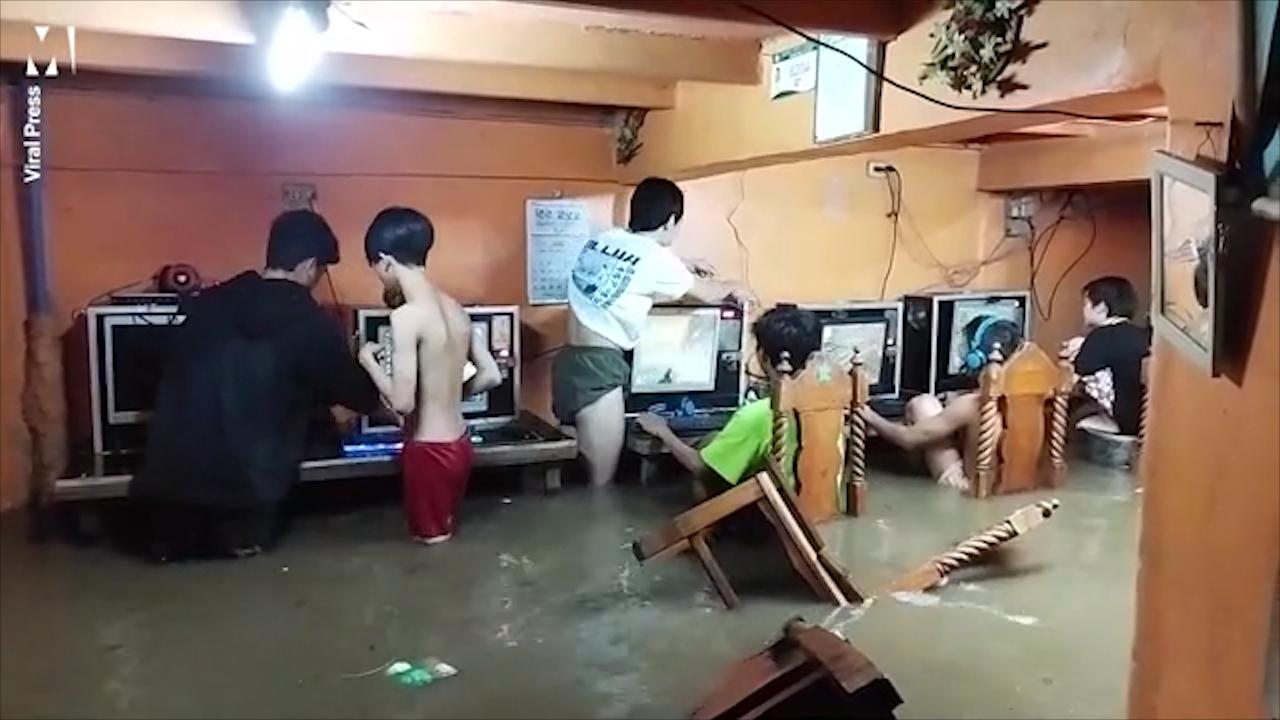 铁杆玩家！菲律宾一家网吧被淹男孩们坐在水中打游戏